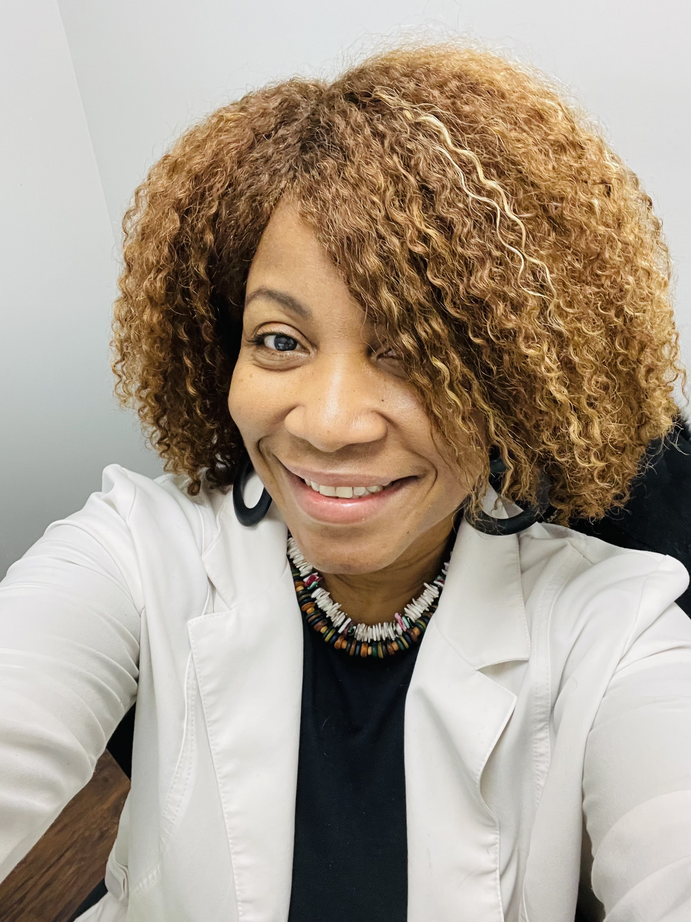 Portrait of Dr. Suzie Collin smiling in a white coat